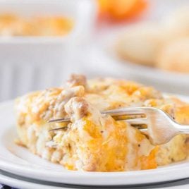 close up shot of a serving of Biscuits and Gravy Breakfast Casserole on a plate with a fork