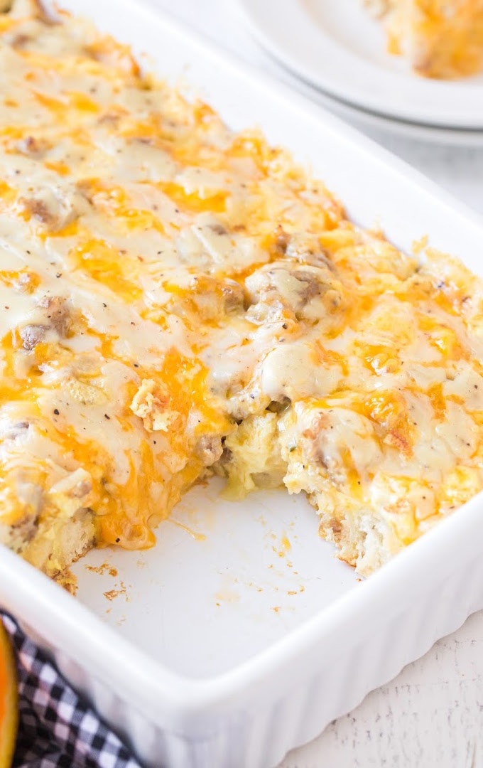 close up shot of biscuits and gravy breakfast casserole in a white baking pan