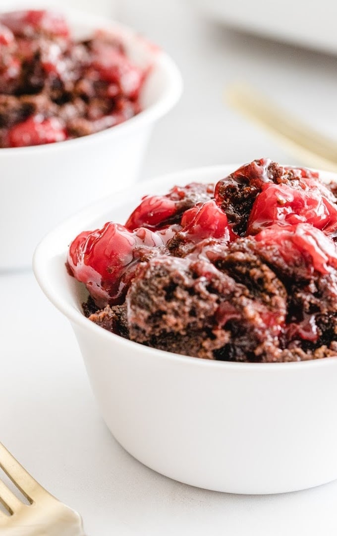 close up shot of chocolate cherry dump cake in a white bowl