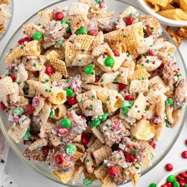 Large bowl of Christmas Chex Mix filled with crunchy cereal, pretzels, Bugles, M&Ms, and peppermint pieces.