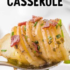 close up overhead shot of a serving of Hasselback Potato Casserole garnished with bacon bits and green onions on a fork