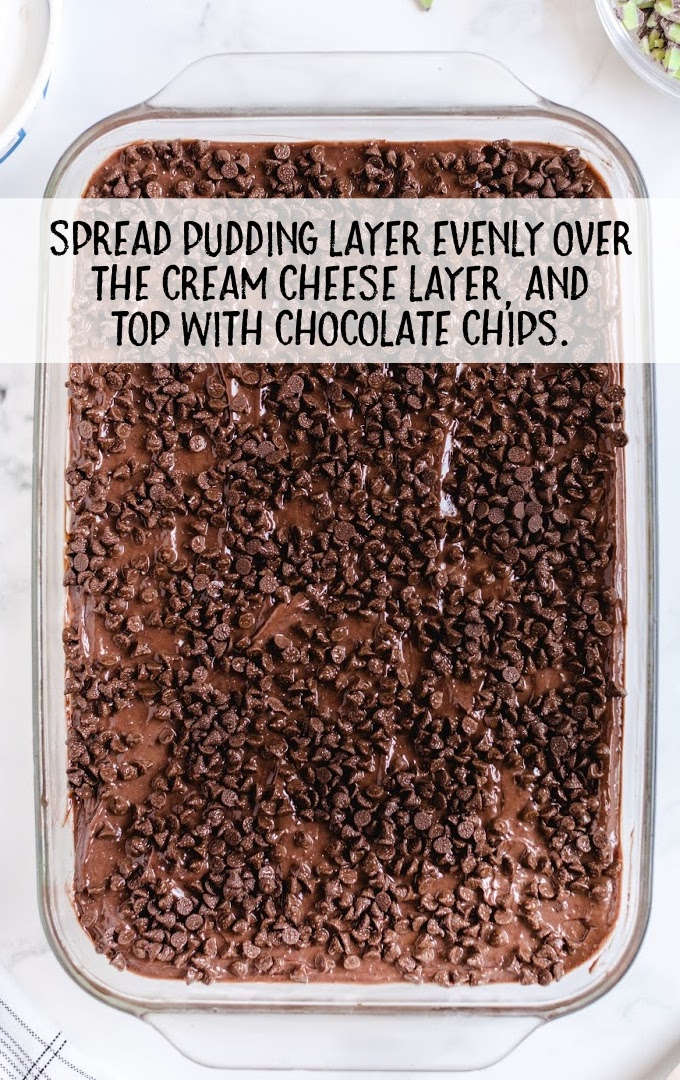 pudding layer spread on top of the cream cheese layer and topped with chocolate chips in a baking dish