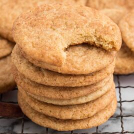 close up shot of Snickerdoodle Cookies Recipe stacked on top of each other on a cooling rack