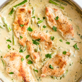 overhead shot of creamy chicken and asparagus in a pan