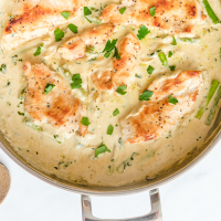 close up overhead shot of creamy chicken and asparagus in a pan