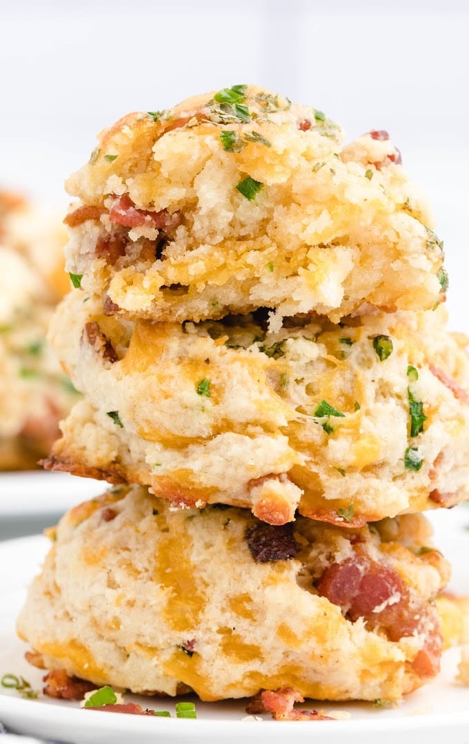 close up shot of bacon cheddar biscuits stacked on top of each other
