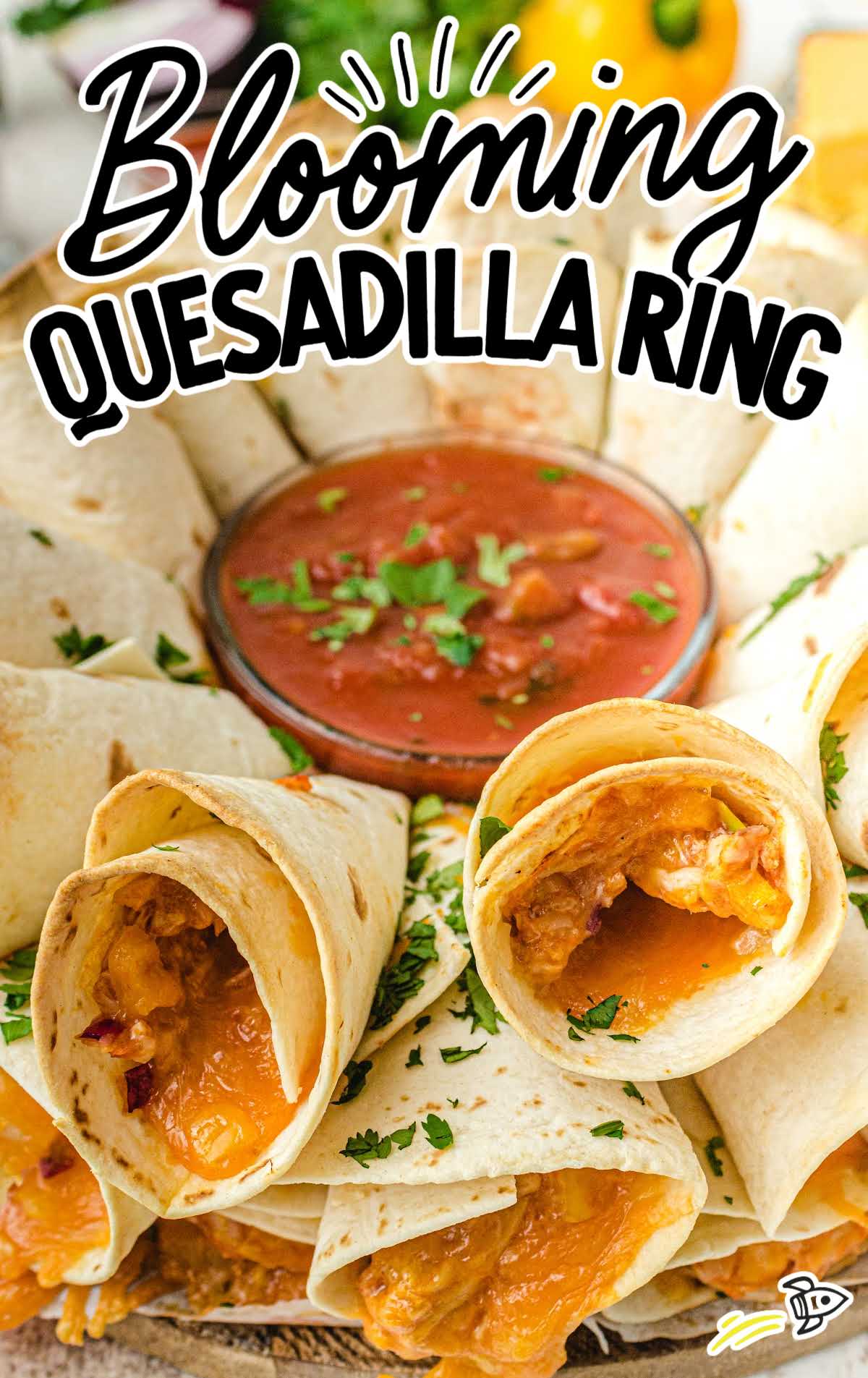 close up shot of blooming quesadilla ring arranged on a dish with dipping sauce in the middle