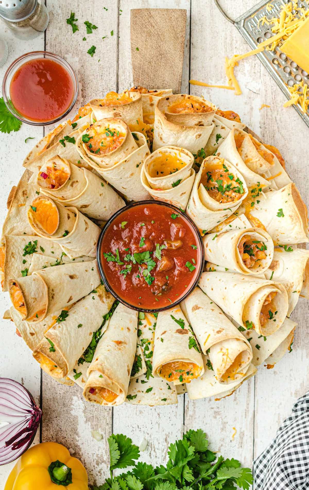 close up over head shot of blooming quesadilla ring garnished and arranged on a plate with dipping sauce in the middle