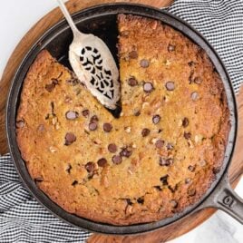 close up overhead shot of a cast iron with Cast Iron Banana Bread with a slice missing