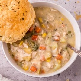 close up overhead shot of a bowl of Chicken Pot Pie Soup with a piece of bread