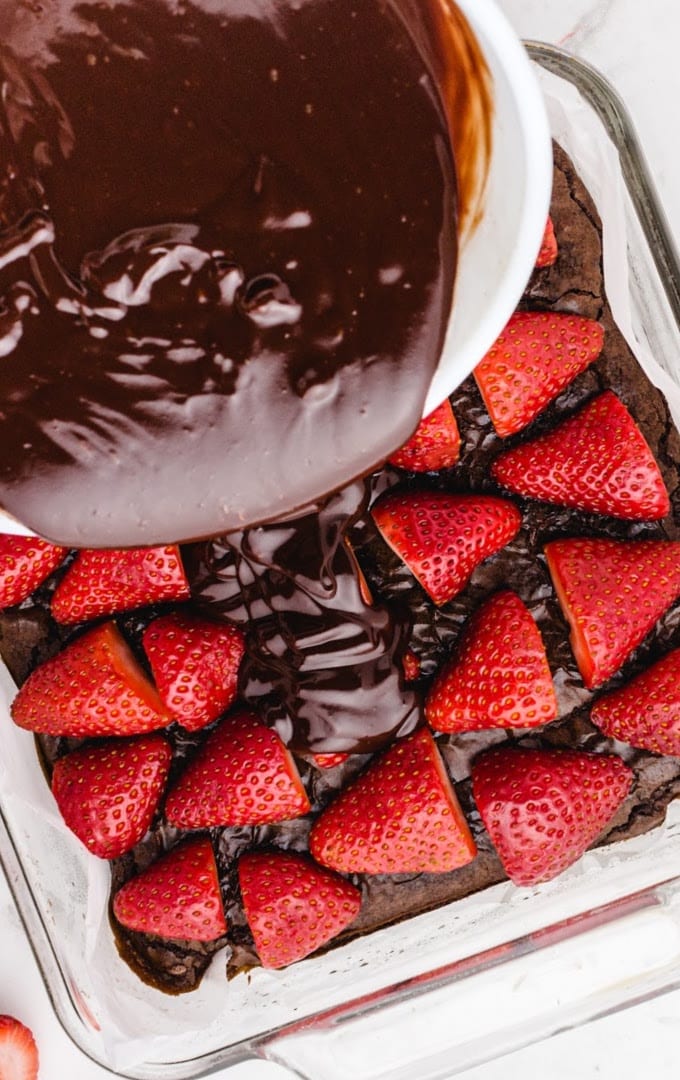 close up of Chocolate Covered Strawberry Brownies with chocolate being poured