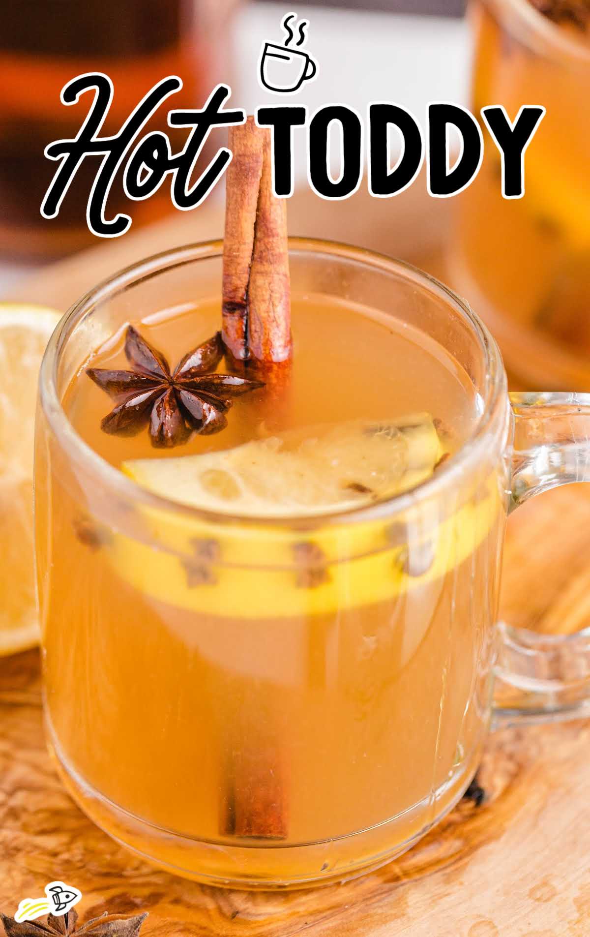 close up shot of a glass mug of Hot Toddy garnished with cinnamon, star anise, and lemon