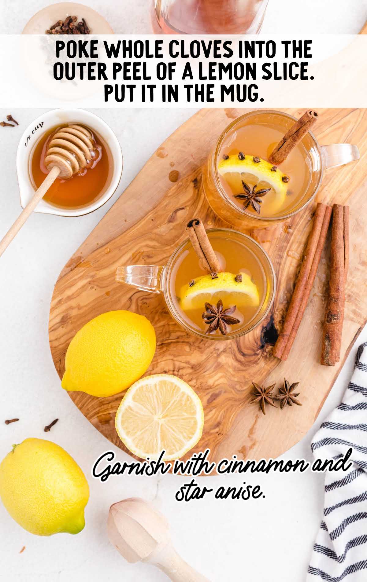 glass mugs of Hot Toddy garnished with cinnamon, star anise, and lemon