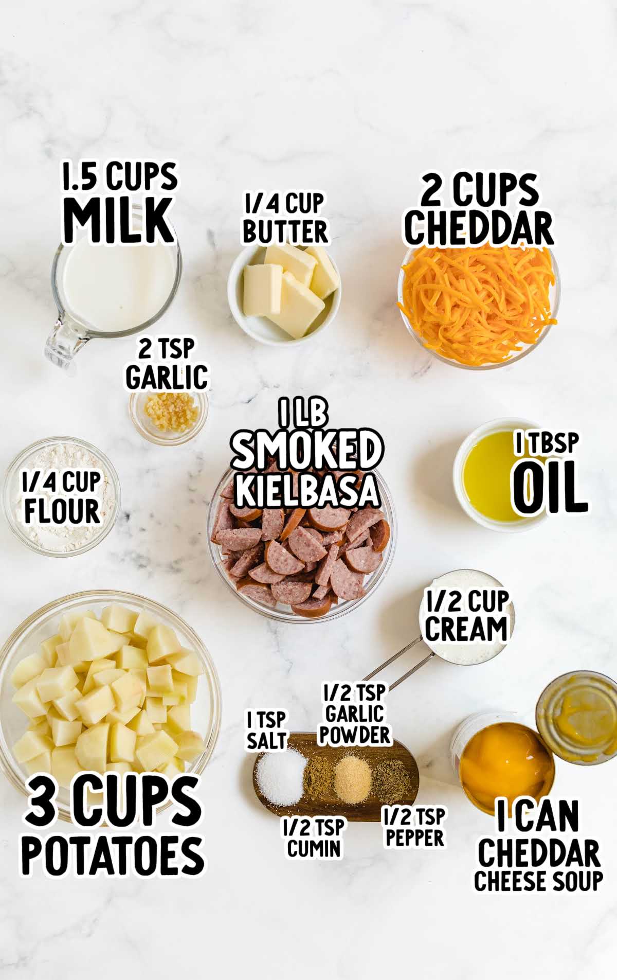 Flat lay of labeled ingredients for kielbasa and potato bake including potatoes, smoked kielbasa, cheddar, milk, garlic, and spices.