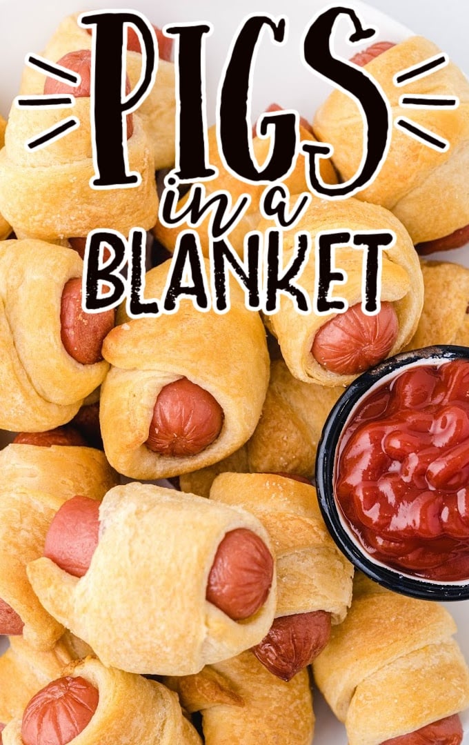 close up shot of pigs in a blanket on a white plate with dipping sauce
