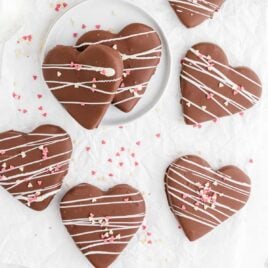 close up overhead shot of chocolate covered peanut butter hearts drizzled with white chocolate and topped with heart sprinkles