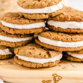 close up side shot of oatmeal cream pies stacked on top of each other on a board