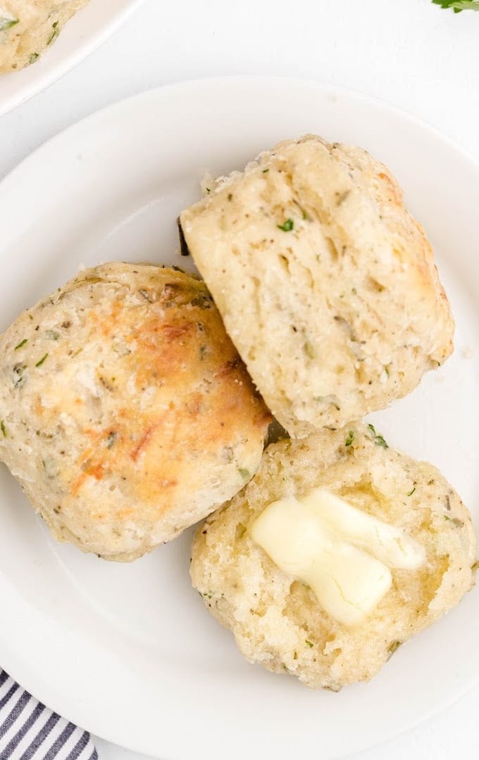 close up overhead shot of cheese and herb biscuits on a white plate