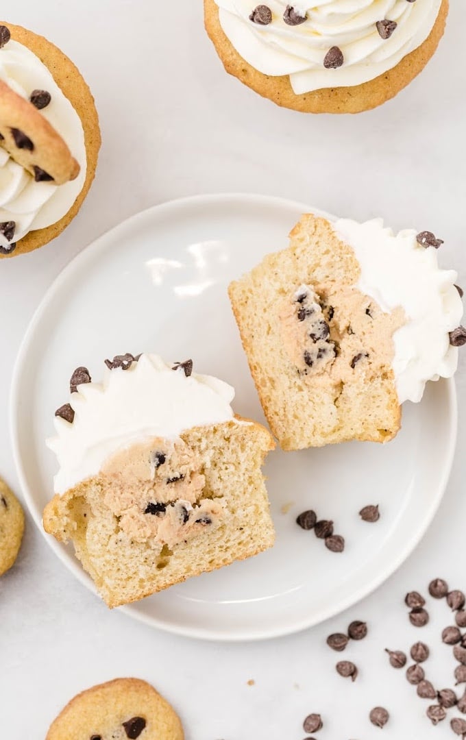 close up overhead shot of cookie dough cupcakes sliced in half on a white plate
