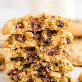 close up side shot of oatmeal chocolate chip cookies stacked on top of each other showing their inside chocolate layer