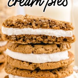 side shot of oatmeal cream pies stacked on top of each other on a board with a piece taken out of the top pie