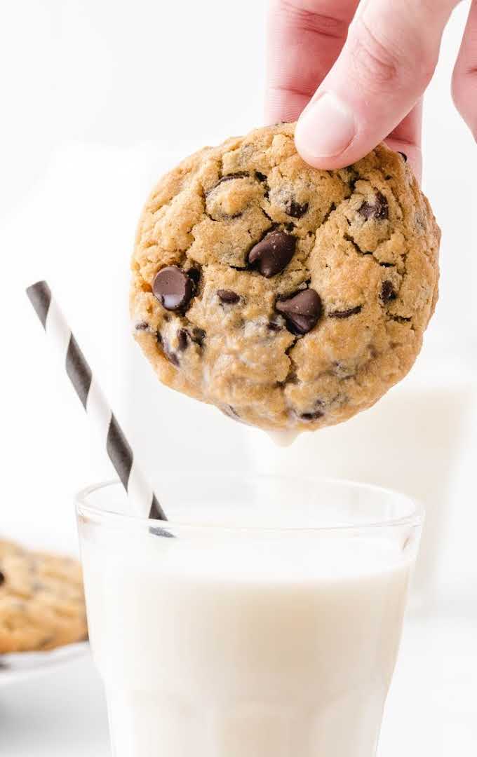 peanut butter oatmeal cookies being pipped into a glass of milk