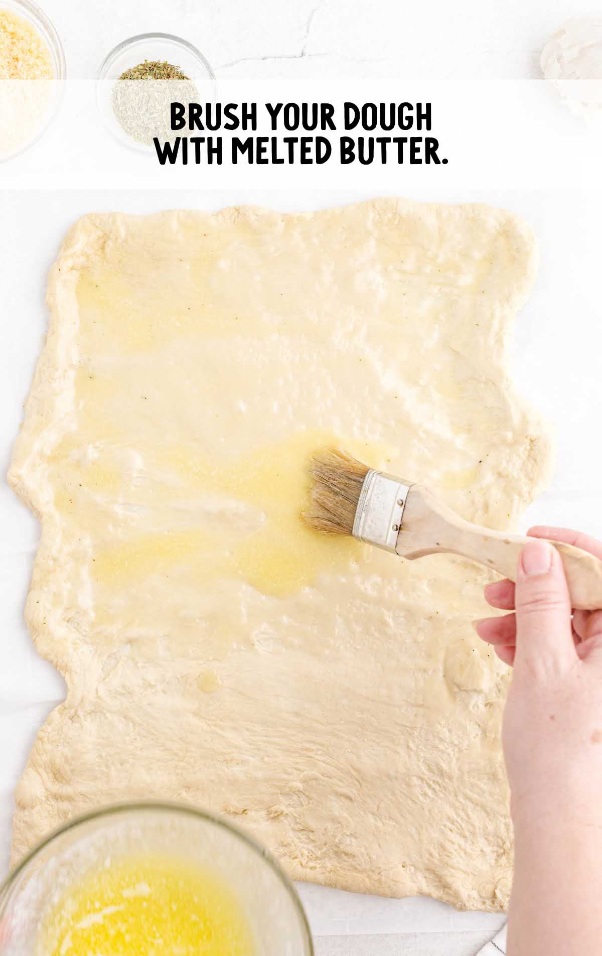 dough being brushed with melted butter