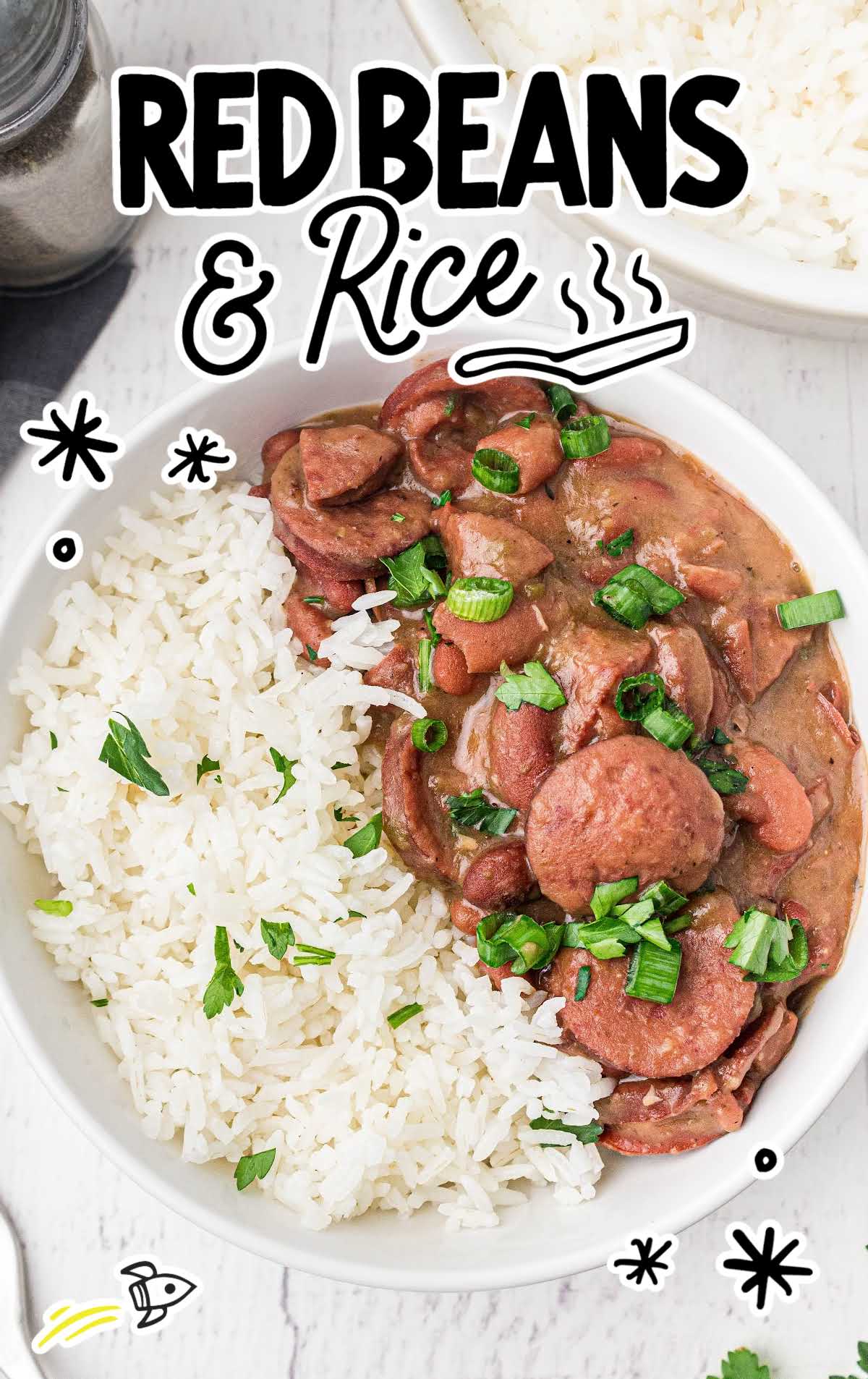 close up shot of a bowl of red beans and rice garnished with green onions and served with white rice