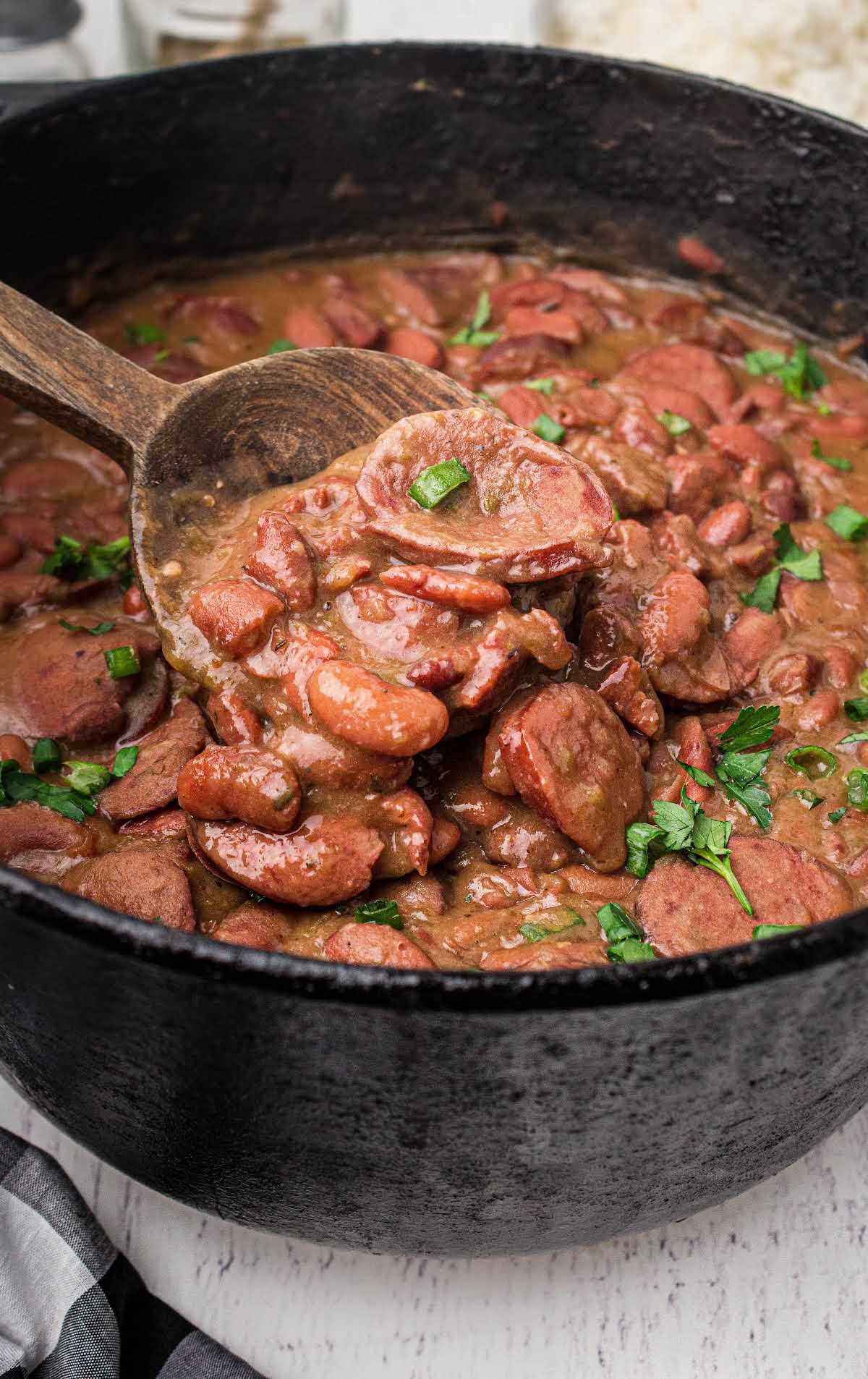 a pot of red beans and rice garnished with green onions