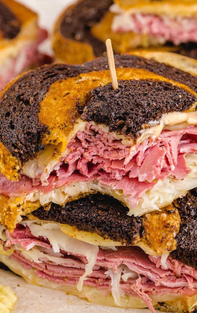 close up shot of reuben sandwich stacked on top of each other