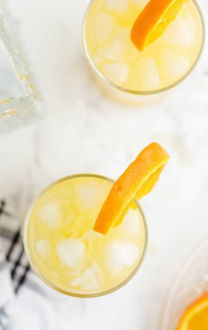 screwdriver cocktail overhead shot of cocktail in glass served with a side of sliced orange