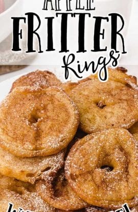 close up shot of apple fritter rings piled on top of each other and drizzled with powder sugar on a white plate