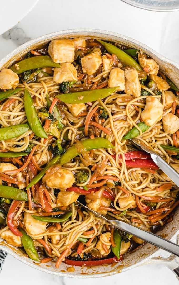 close up overhead shot of chicken lo mein in a pan with tonsils