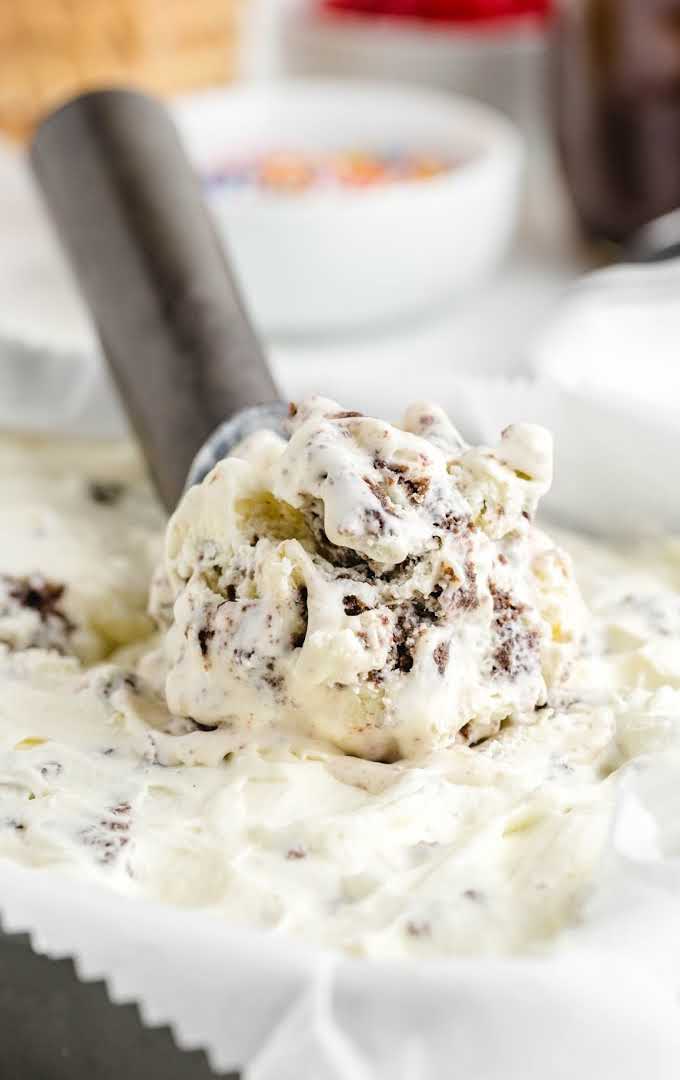 cookies and cream ice cream in a dish being scooped up with a ice cream scooper