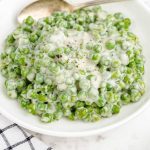 close up shot of creamed peas on a bowl with a spoon
