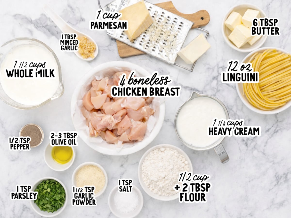 Overhead flat-lay of labeled ingredients for creamy chicken pasta on a marble surface, including 4 boneless chicken breasts, 12 oz linguini, 1 cup Parmesan, 6 tbsp butter, 1&frac14; cups heavy cream, 1&frac12; cups whole milk, &frac12; cup plus 2 tbsp flour, 2&ndash;3 tbsp olive oil, 1 tbsp minced garlic, 1&frac12; tsp garlic powder, 1 tsp parsley, 1 tsp salt, and &frac12; tsp pepper.