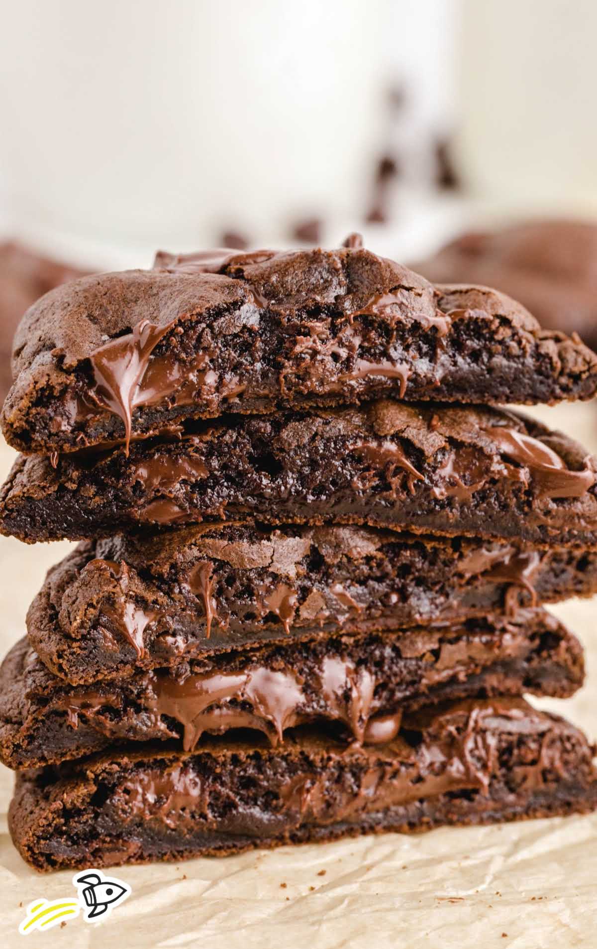 close up shot of double chocolate chip cookies stacked on top of each other showing their melted chocolate inside
