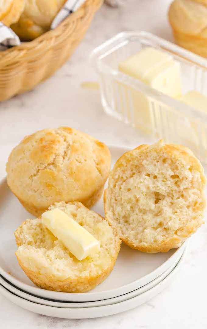 No Yeast Dinner Rolls broke open with butter on top on a white plate
