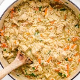 overhead shot of a pot of One Pot Chicken and Rice with a wooden spoon