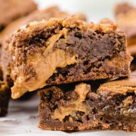 close up shot of peanut butter brownies stacked on top of each other on a wooden board