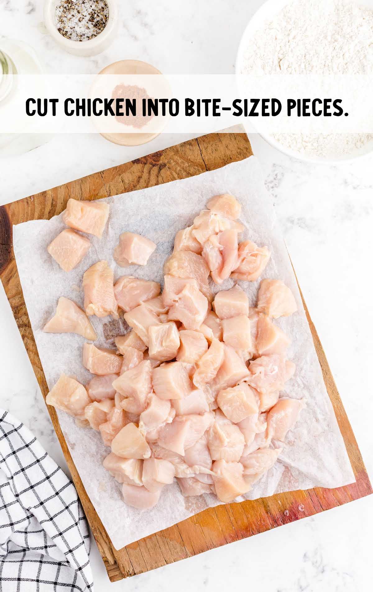 chicken cut into bite size pieces on a wooden board