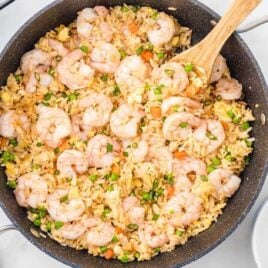 overhead shot of a skillet of Shrimp Fried Rice garnished with green onions
