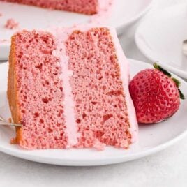 a slice of strawberry cake with a strawberry on a plate