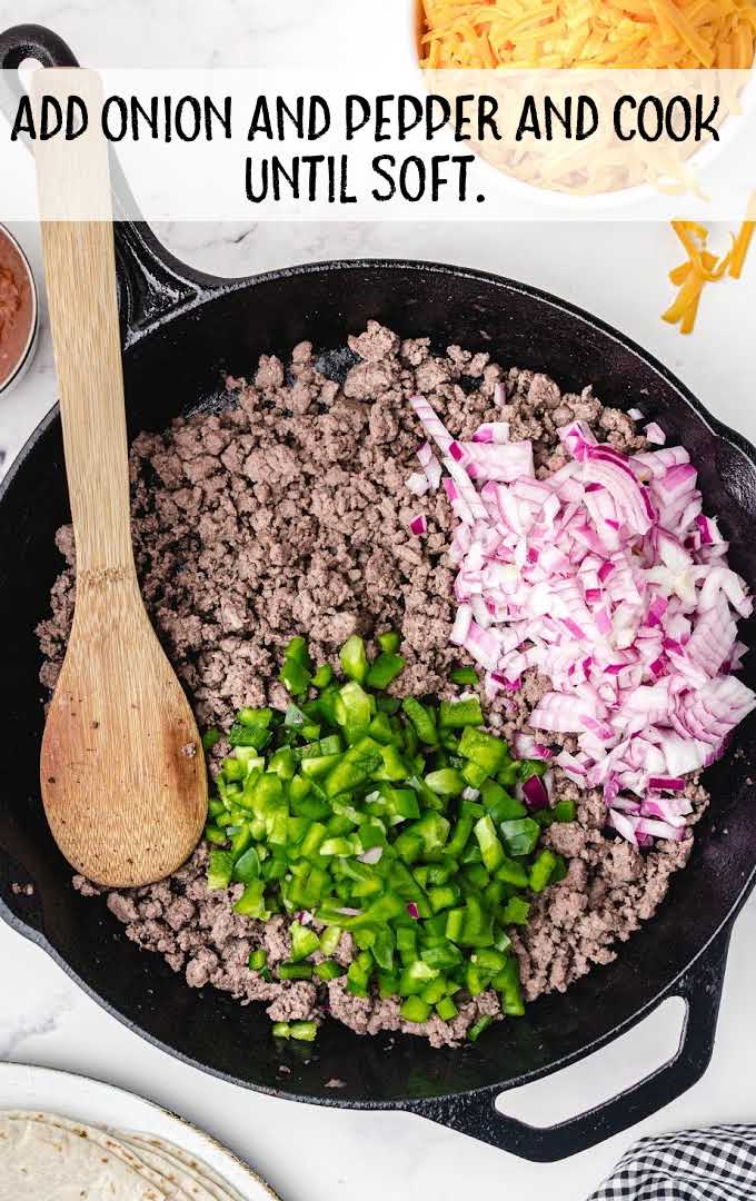onion and green bell pepper added to the cooked beef in the skillet