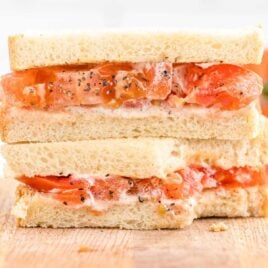 close up shot of a Tomato Sandwich on a wooden cutting board