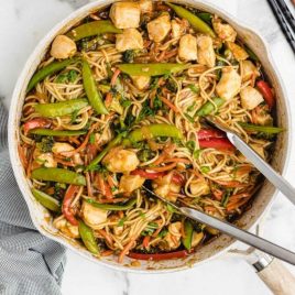 close up overhead shot of chicken lo mein in a pan with tonsils