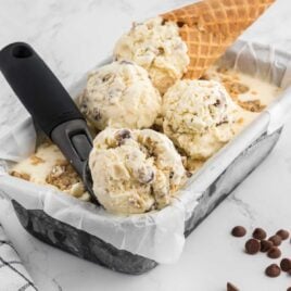 close up shot of Cookie Dough Ice Cream in a pan with some being scooped out with a ice cream scooped