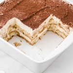 close up shot of easy tiramisu recipe in a baking dish with slices missing