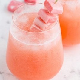 close up shot of pink starburst cocktail with starburst candy in a glass