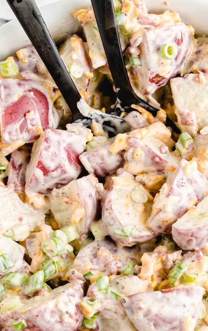 close up overhead shot of ranch potato salad drizzled with ranch dressing and garnished with green onions